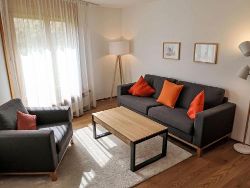 a living room with a couch and a table at Apartment Utoring Acletta-2 by Interhome in Disentis