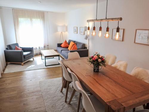 a living room with a wooden table and a couch at Apartment Utoring Acletta-2 by Interhome in Disentis
