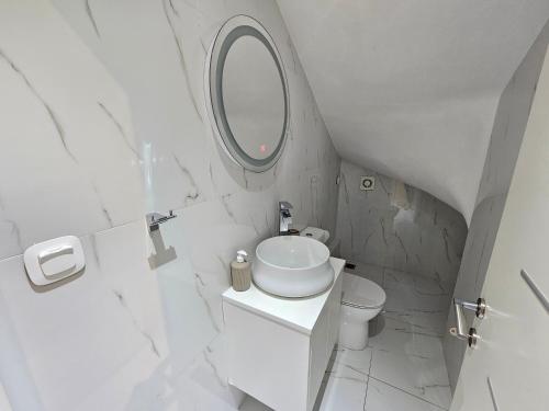 a white bathroom with a sink and a mirror at GREY LUXURY HOUSE in Ýpsos