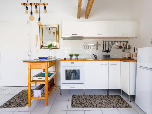 une cuisine avec des armoires blanches et une table dans l'établissement Apartment l'Escurial by Interhome, à Nice