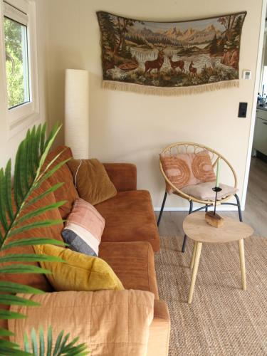 un soggiorno con divano e tavolo di Gezellig gemoderniseerd chalet op de Veluwe a Putten