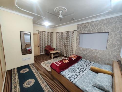 a bedroom with a bed and a white board on the wall at Home Away From Home Cute 3 bedroom House G floor in Srinagar