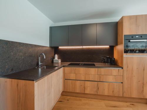 a kitchen with wooden cabinets and a sink at Apartment Lakeside Luxury Apartments by Interhome in Zell am See