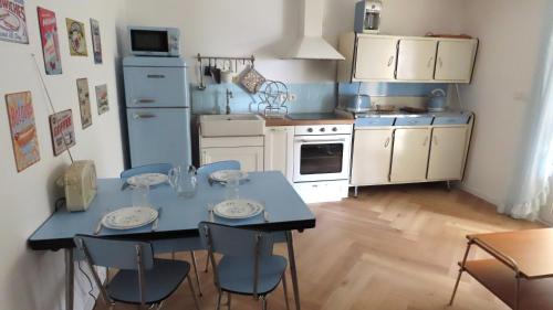 une petite cuisine avec une table bleue et des chaises dans l'établissement La Rose & Le Loup, à Spéracèdes