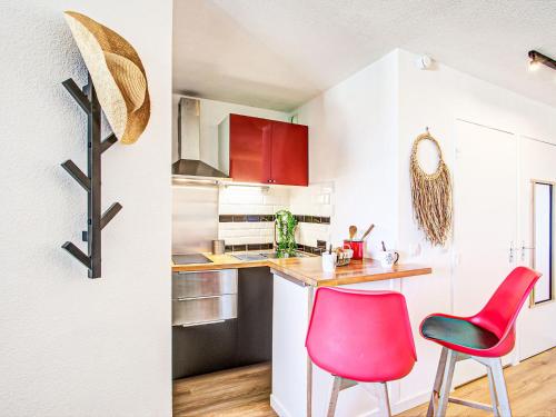 une cuisine avec des armoires et des fauteuils rouges et blancs dans l'établissement Apartment Ipanema Sud-15 by Interhome, à Canet