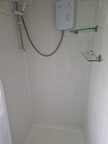 La salle de bains blanche est pourvue d'une douche et de toilettes. dans l'établissement The Cabin - a very quiet location, à Pewsey
