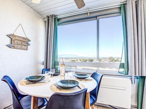 une salle à manger avec une table et des chaises et une grande fenêtre dans l'établissement Apartment Ipanema Sud-15 by Interhome, à Canet