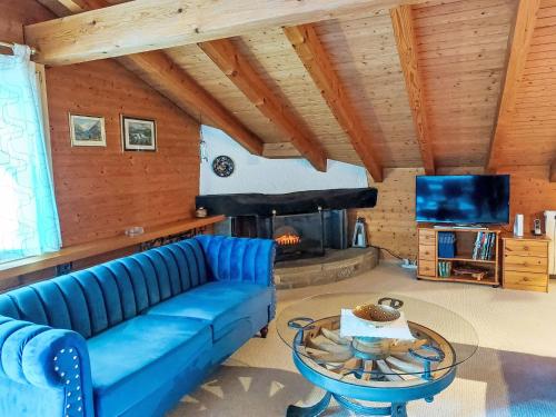 ein Wohnzimmer mit einem blauen Sofa und einem Kamin in der Unterkunft Apartment Chalet Bienli-2 by Interhome in Grindelwald