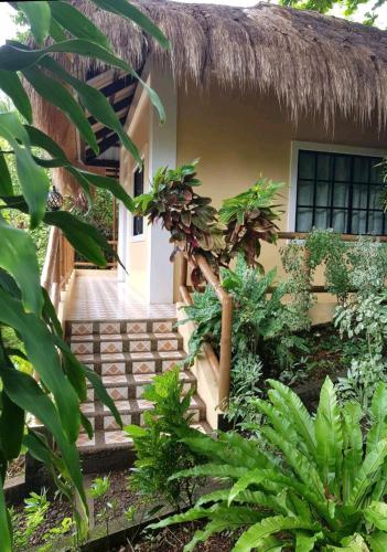 a house with a thatched roof and stairs to the entrance at Palmhill Villa in Boracay