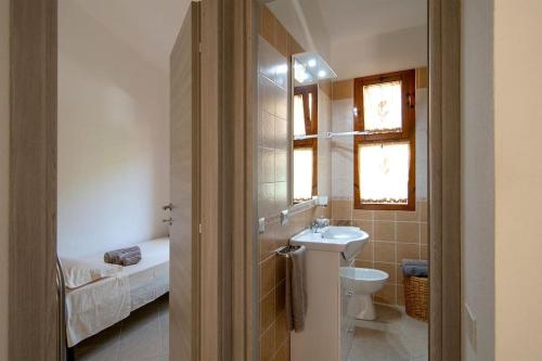 uma casa de banho com um lavatório e um WC em Villetta con giardino a 500 mt dalla spiaggia em Marongiu