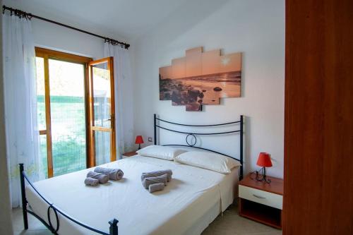 um quarto com uma cama com duas toalhas em Villetta con giardino a 500 mt dalla spiaggia em Marongiu