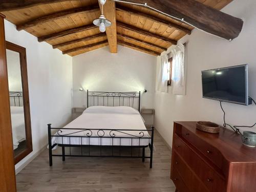 a bedroom with a bed and a flat screen tv at Casa Locci in San Vito