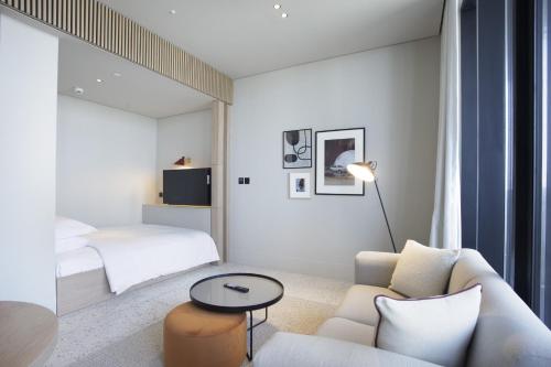 een woonkamer met een bank en een bed bij Business Travel Ready Studio at Upside Living in Dubai
