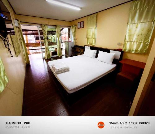 1 dormitorio con 1 cama con sábanas y almohadas blancas en โรงแรมดีเทล en Ban Khlong Ngiu