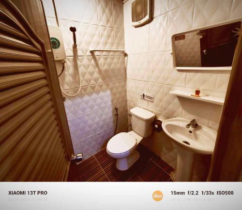 Baño pequeño con aseo y lavamanos en โรงแรมดีเทล en Ban Khlong Ngiu