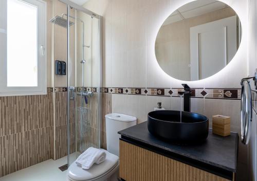 a bathroom with a black sink and a mirror at Renovado en el centro ascensor a la playa cerca in Torremolinos
