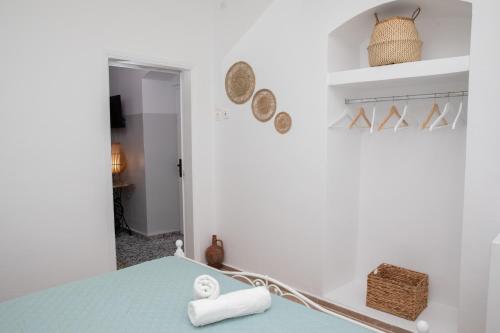 a white room with a blue table and a mirror at Melitini's House in Alinda