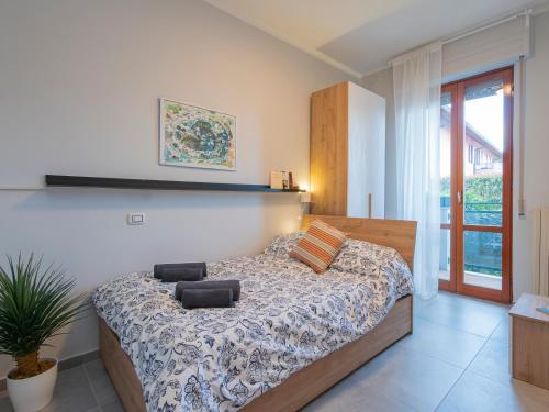 ein Schlafzimmer mit einem Bett und einer Pflanze darin in der Unterkunft Rho Fiera - Ideale per famiglie e viaggi di lavoro in Rho