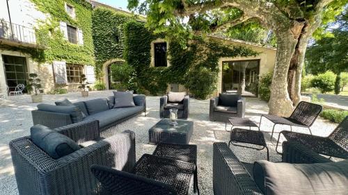 アヴィニョンにあるMas Château Blancのソファと椅子、木のあるパティオ