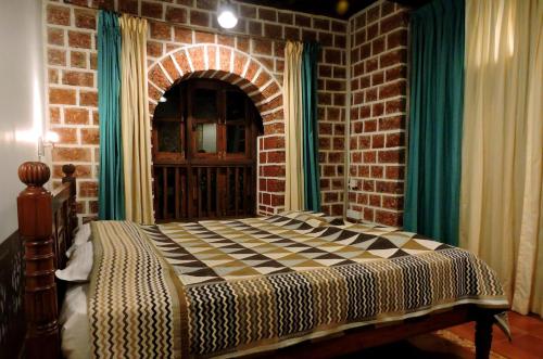 a bedroom with a bed in a brick wall at Verandah By The Sea in Vengurla