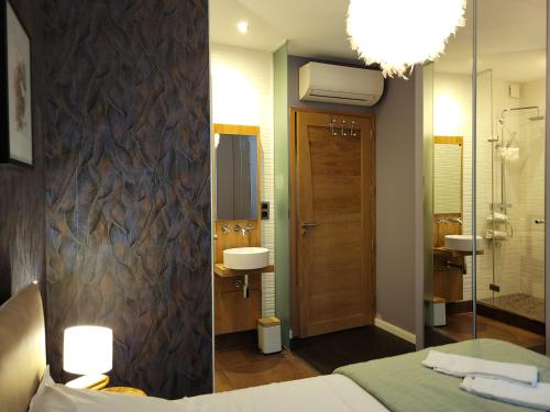 een badkamer met een bed, een wastafel en een spiegel bij L'Eau Vive Jacuzzi et Sauna en vieille ville 5 in Annecy