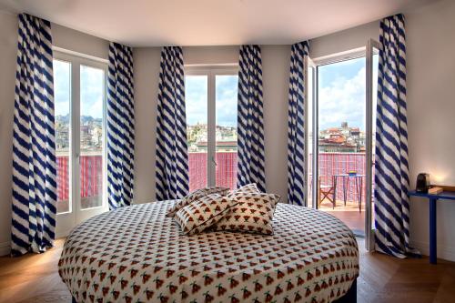 una camera da letto con un letto con cuscini davanti alle finestre di Galleria Port'Alba - Suites & Rooftop a Napoli