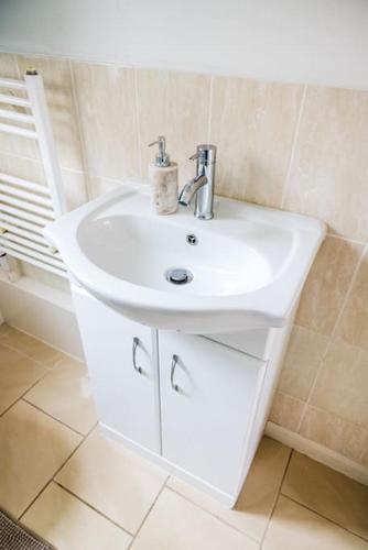 a bathroom with a white sink in a room at Modern 2 Bed Flat Free Parking City Centre in Spon End