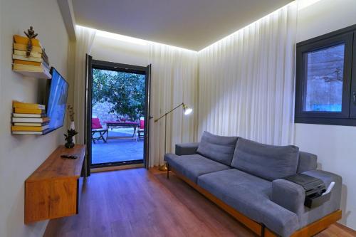a living room with a couch and a tv at P Faliro Riviera Suite in Athens