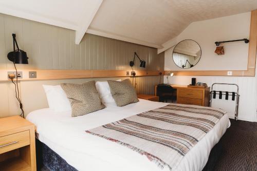 1 dormitorio con 1 cama blanca grande y espejo en Hotel VARA en Truro