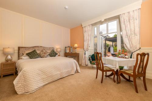 グレンジ・オーバー・サンズにあるGrange Manorのベッドルーム1室(ベッド1台、テーブル、椅子付)