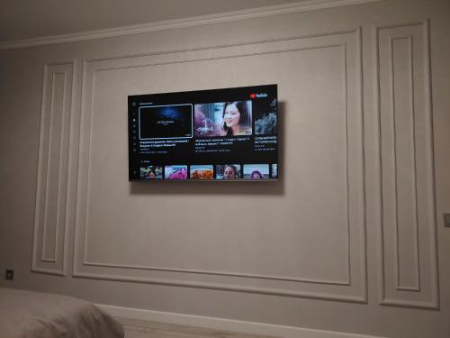 TV de pantalla plana en una pared blanca en Однакомнатная LUX квартира, en Ekibastuz