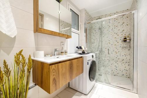 a bathroom with a sink and a washing machine at Apartment anghome A3 in Metaksourgio in Athens