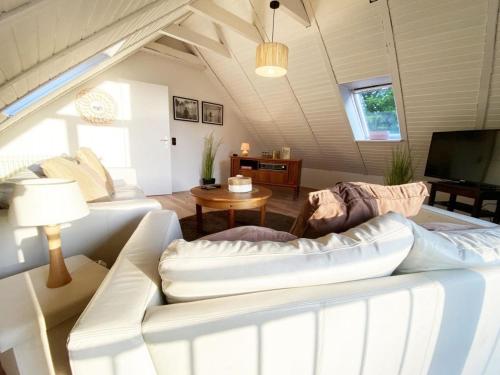 ホールマージールにあるFerien im Wangerland - Haus Wiesenweg - Ferienwohnung 2の白いソファとテレビのあるリビングルーム