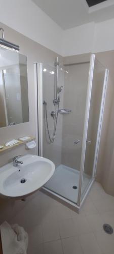 biała łazienka z prysznicem i umywalką w obiekcie Hotel K2 w mieście Numana