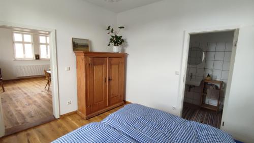 a bedroom with a bed and a wooden cabinet at Rittergut Thürungen in Kelbra