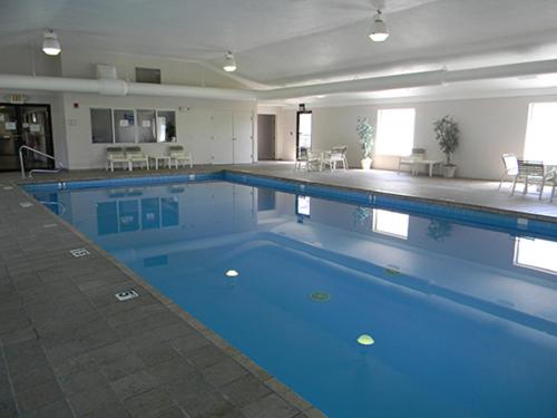a large swimming pool with blue water in a building at Boarders Inn & Suites by Cobblestone Hotels - Munising in Wetmore