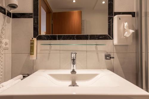 a bathroom with a white sink and a mirror at ALPENAPART LADIS ehemals Alpenapart Alexander in Ladis