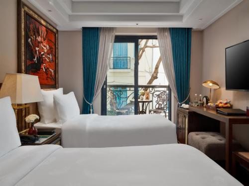 a hotel room with two beds and a balcony at Peridot Gallery Classic Hotel in Hanoi