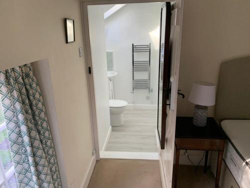 a hallway with a bathroom with a toilet and a doorway at River Cottage a country retreat in wooded gardens in East Stoke