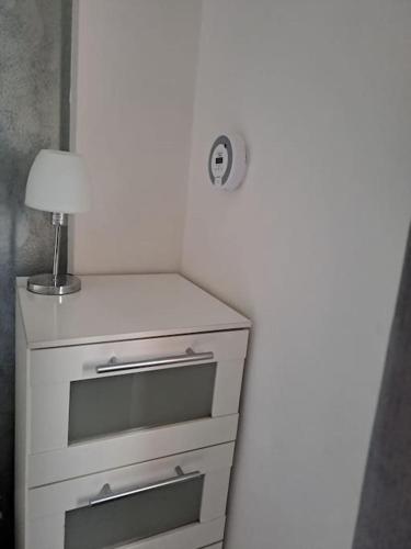 a white dresser with a lamp on top of it at Appartamento Sun and Sea in Campora San Giovanni