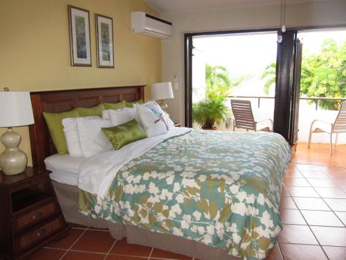 1 dormitorio con 1 cama grande y balcón en Holiday Home at Rio Mar, en Río Grande