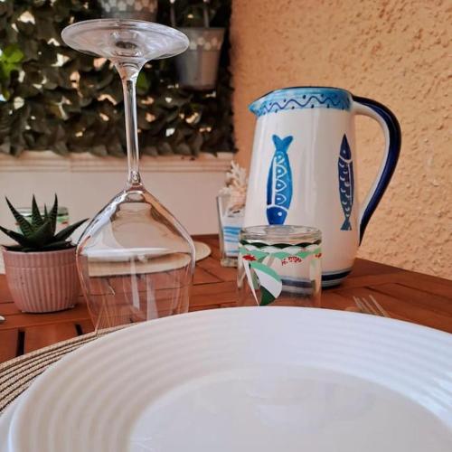 a table with a white plate and a wine glass at Appartamento Sun and Sea in Campora San Giovanni