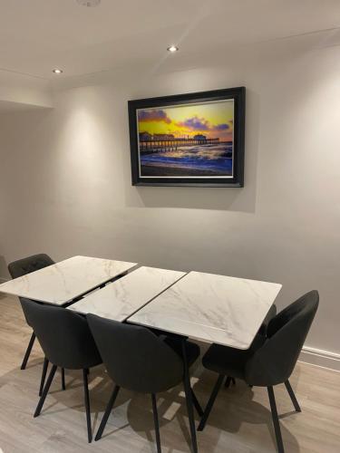 uma mesa de jantar com cadeiras e um quadro na parede em 2Philipot em Eltham