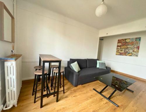 ein Wohnzimmer mit einem Sofa und einem Tisch in der Unterkunft 15 min from the Eiffel Tower - Charming apartment in Issy-les-Moulineaux