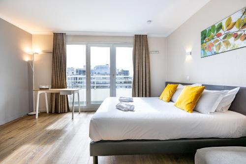 1 dormitorio con 1 cama grande con almohadas amarillas en Star Of Life, en Courbevoie