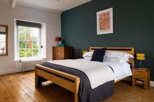 a bedroom with a bed and a green wall at Georgian Home with Heated Swimming Pool in Crewkerne