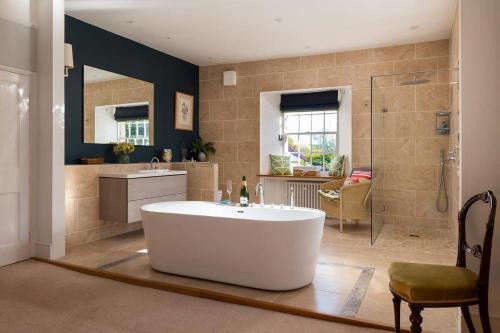 a large bathroom with a tub and a shower at Georgian Home with Heated Swimming Pool in Crewkerne