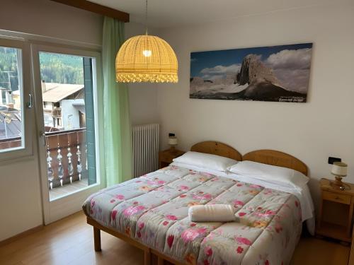 - une chambre avec un lit et une grande fenêtre dans l'établissement B&B Meublè Giustina, à Auronzo di Cadore