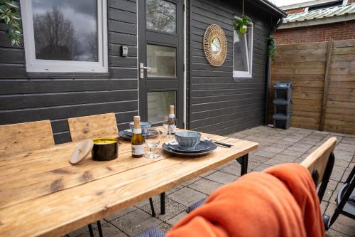 een houten tafel met eten en drinken op een patio bij Huisje Kerkepad in Gorredijk