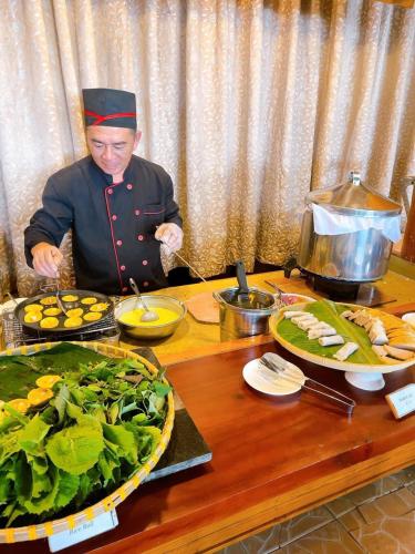 um homem vestido de chef comendo em uma mesa em Tan Son Nhat Con Dao Resort em Con Dao